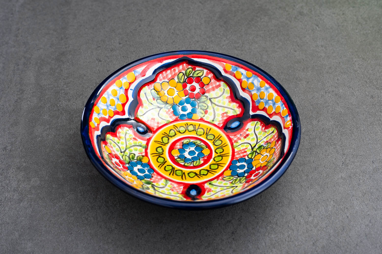 bunter Bowl rot-blau-gelb mit Blumen auf Schieferplatte