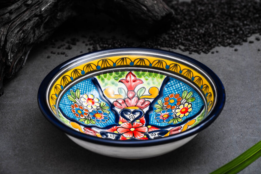 bunter Bowl blau-grün-gelb mit Blumen auf feuchter Schieferplatte