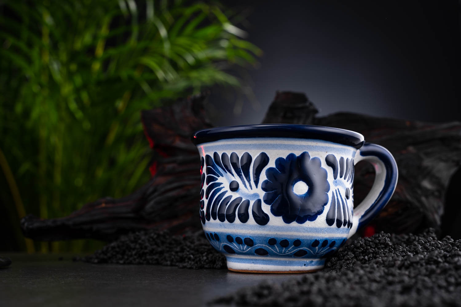meeresfrische Kaffeetasse blau-weiß auf Schieferplatte mit Deko und Palmenblättern