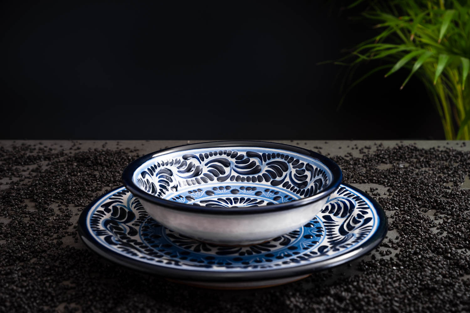 Set meeresfrischer Bowl und Essteller blau-weiß auf Schieferplatte mit Deko und Palmenblättern