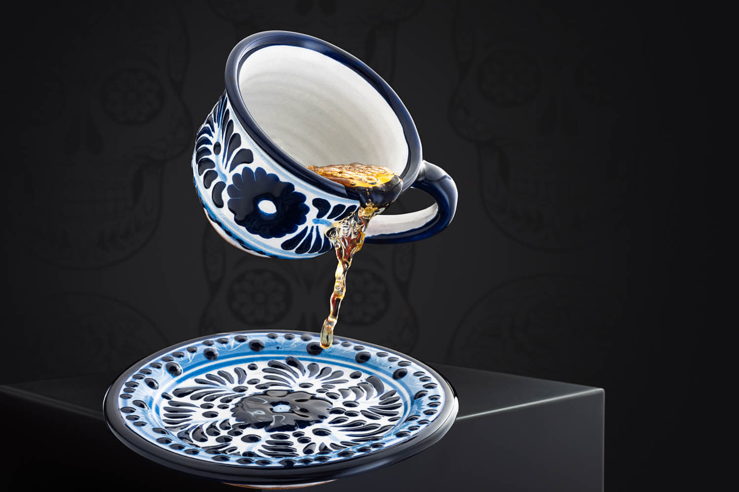 Set meeresfrische Kaffeetasse und Untertasse blau-weiß und eingegoßenem Tee vor mexikanischem Hintergrund