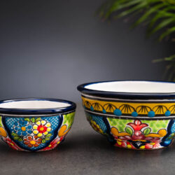 Set buntes Schälchen und Schale blau-grün-gelb mit Blumen auf Schieferplatte mit Palmenblättern